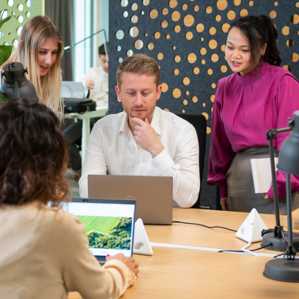 Colleagues gathered around a desk to solve problem